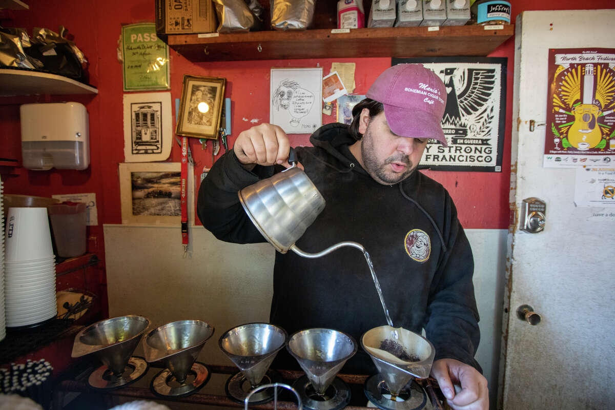 El propietario Nick Floulis sirve un café de goteo en Hole in the Wall Coffee en North Beach en San Francisco el 23 de junio de 2022.