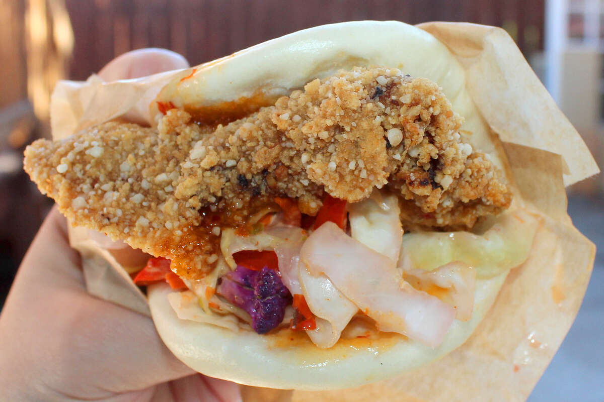 El delicioso bao de pollo frito en Taiwan Bento está repleto de perfumados muslos de pollo crujientes, verduras moradas en escabeche y repollo crujiente.