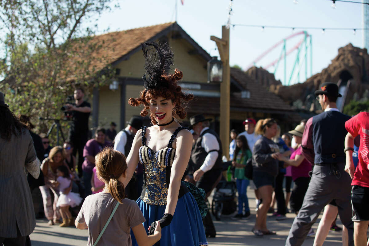 Durante el hoedown del Día del Fundador, la gente del pueblo baila con los visitantes del parque.