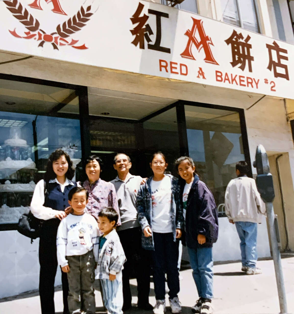 La familia Yu de pie frente a la ubicación de Clement Street de su negocio familiar, Red A Bakery, a mediados de la década de 1990.