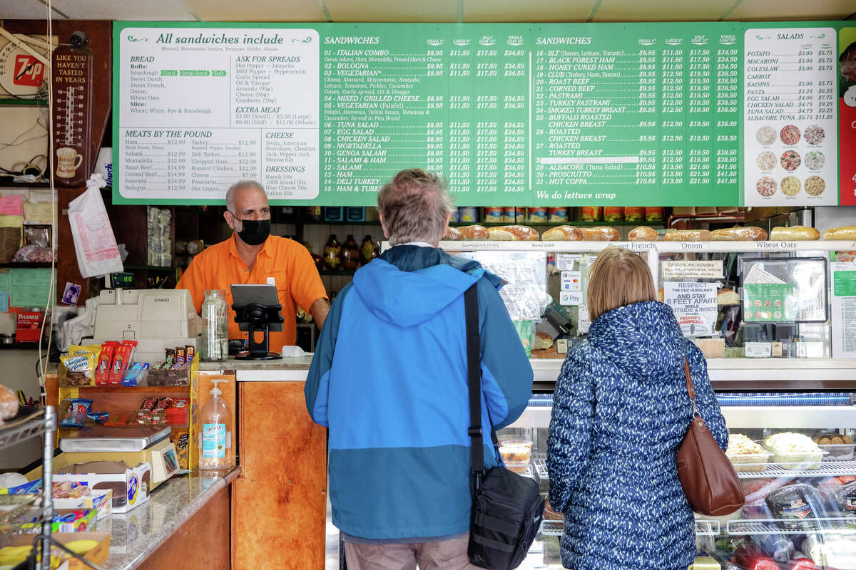 El propietario Eddy Sweileh recibe un pedido de los clientes en Freddie's Sandwiches en el vecindario de North Beach en San Francisco.