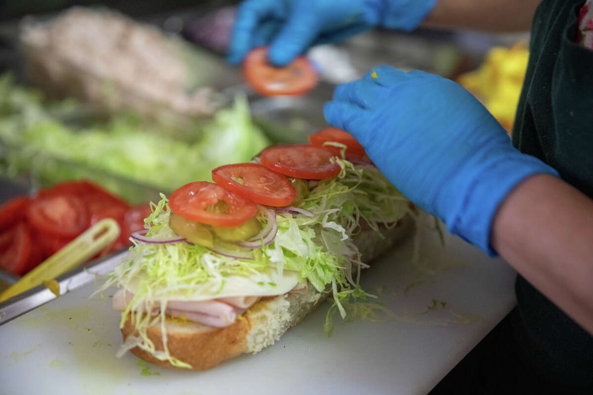 La gerente de Freddie's Sandwiches, Maura Mancia, prepara un sándwich de pavo detrás del mostrador de la tienda de delicatessen North Beach en San Francisco, California, el 28 de julio de 2022.