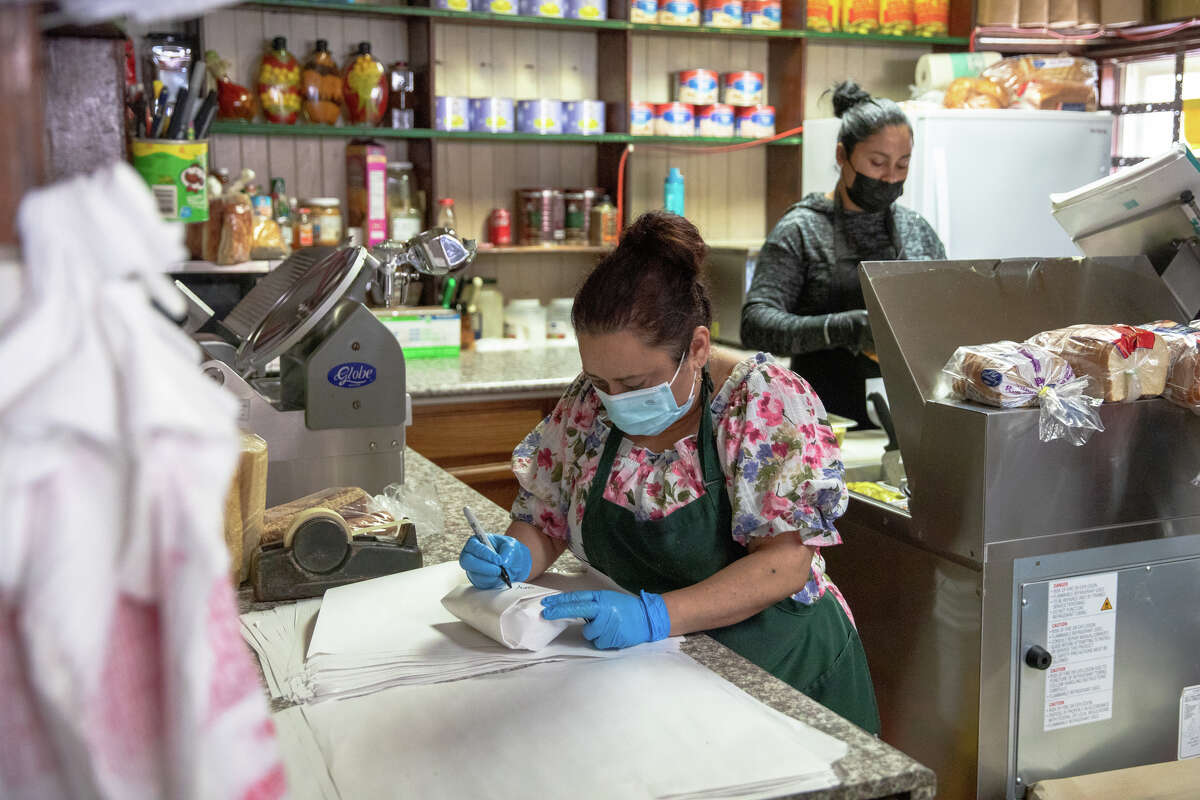 La gerente de Freddie's Sandwiches, Maura Mancia, escribe el nombre de un sándwich detrás del mostrador de la tienda de delicatessen North Beach en San Francisco.