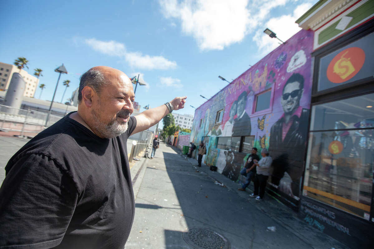 El propietario de Papalote, Víctor Escobedo, habla sobre un mural a lo largo de su nueva tienda, Snackeria, cerca de la estación BART de 24th Street en el Distrito de la Misión de San Francisco el 26 de julio de 2022.