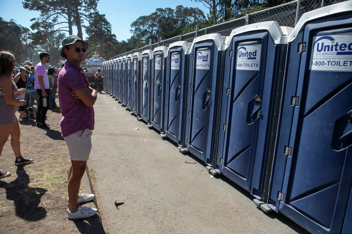 Un asistente al festival espera un baño portátil en Outside Lands en Golden Gate Park en San Francisco el 6 de agosto de 2022.