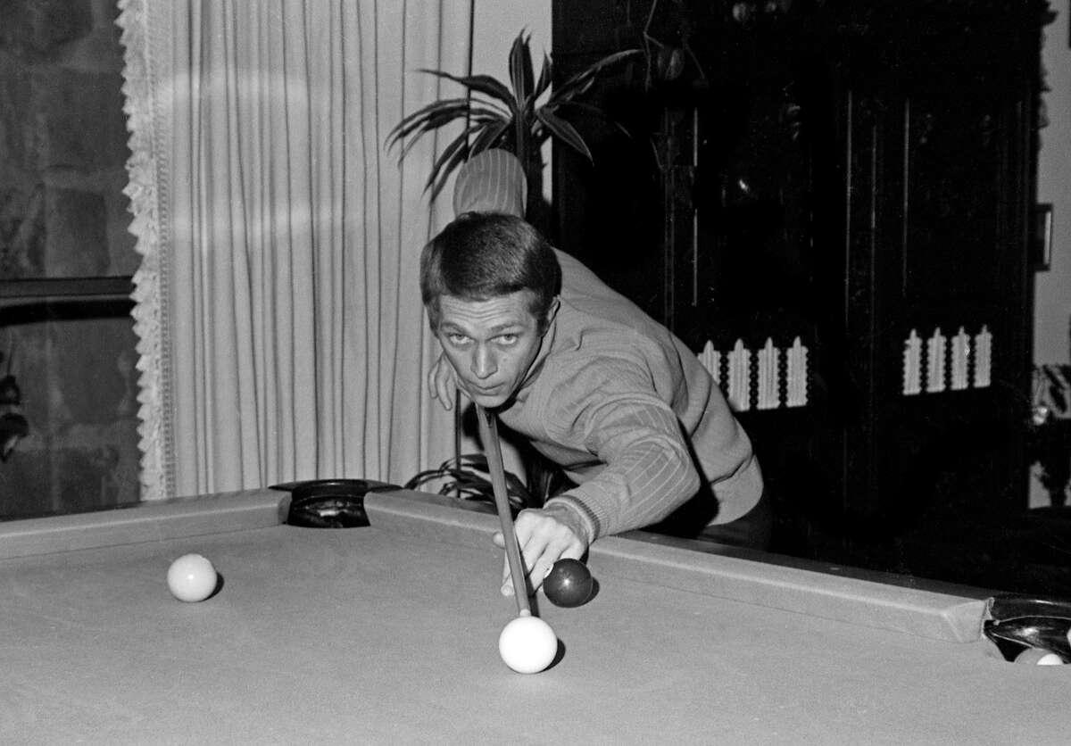 Steve McQueen apunta con un taco mientras juega al billar en su casa, Los Ángeles, 1960. McQueen, como muchas estrellas de esa época y de esta, frecuentaba el Nepenthe de Big Sur.