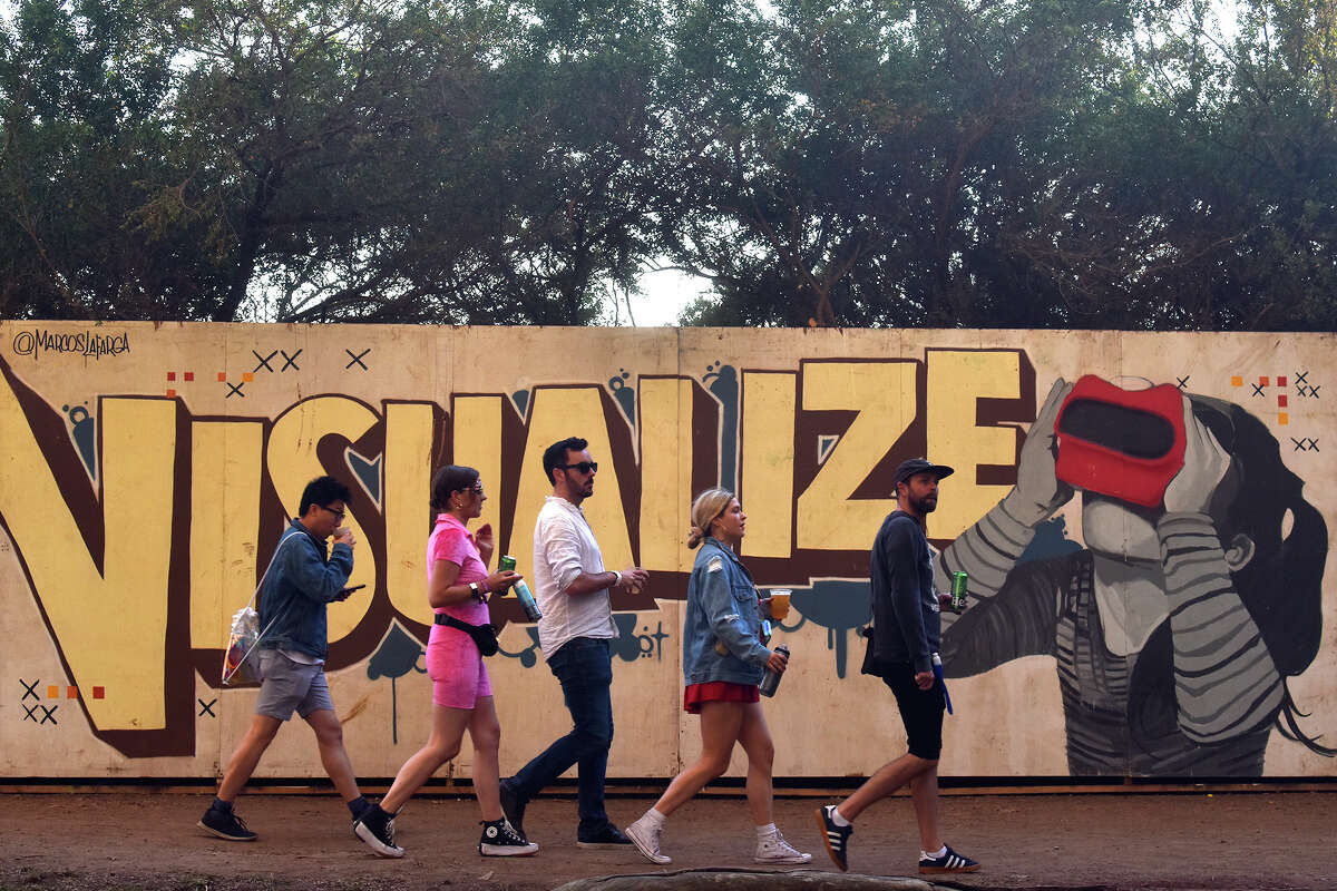 Los asistentes al concierto pasan por uno de los muchos murales a lo largo de los terrenos del festival en Outside Lands, el domingo 7 de agosto de 2022.