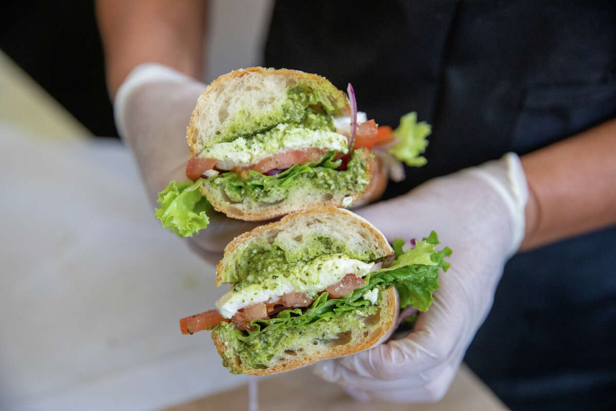 Bertha Due–as sostiene un sándwich caprese en Ratto's deli en Oakland, California, el 3 de agosto de 2022.