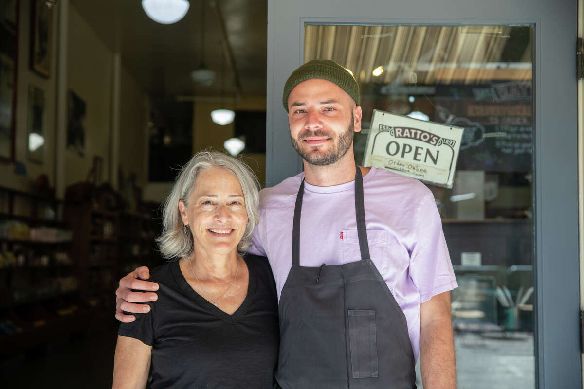 La propietaria Elena Durante posa con su hijo Jonas Voironi frente a la entrada de Ratto's International Deli & Market en Oakland, California, el 3 de agosto de 2022. Durante, la cuarta generación propietaria del mercado y charcutería familiar, eventualmente transferir la propiedad a Jonas, que trabaja como empleado.