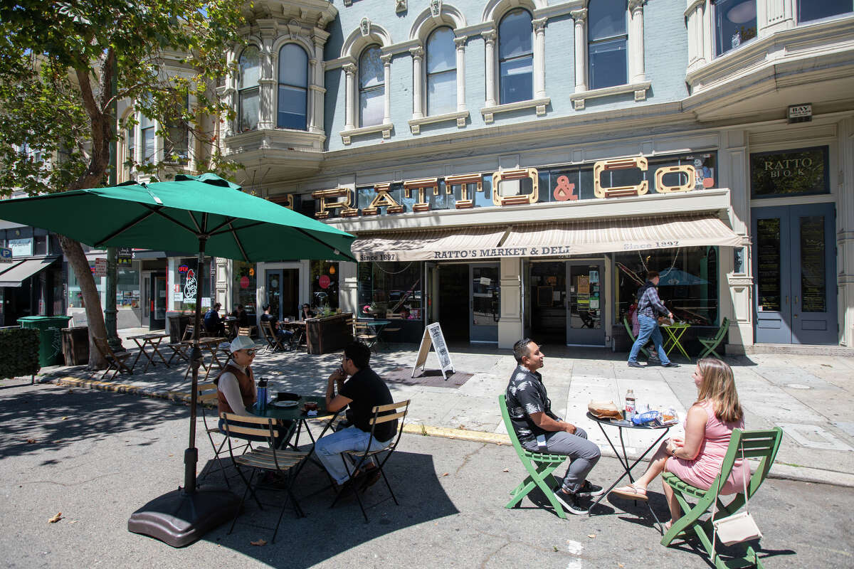 Los clientes disfrutan de su comida en algunos asientos al aire libre frente a Ratto's en Oakland, California, el 3 de agosto de 2022.