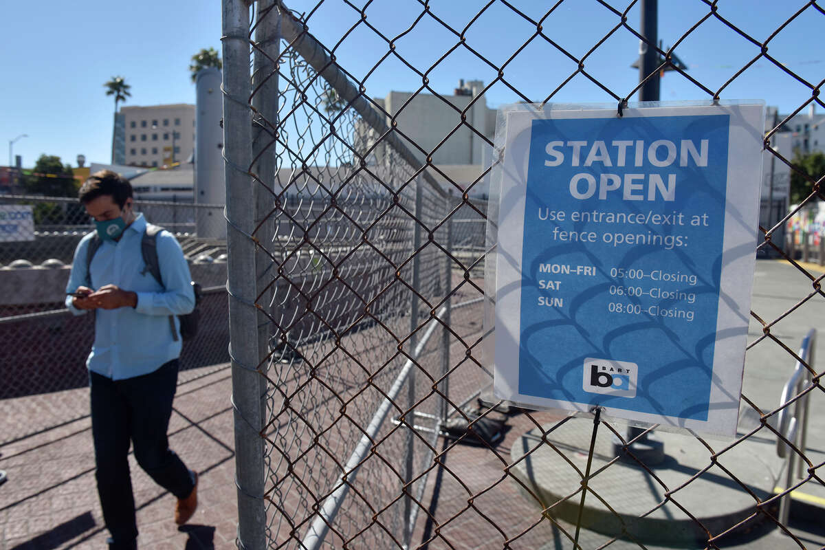 Un viajero sale de la estación BART de 24th Street, en medio de vallas improvisadas en el lado oeste de Mission Street, el martes 23 de agosto de 2022.