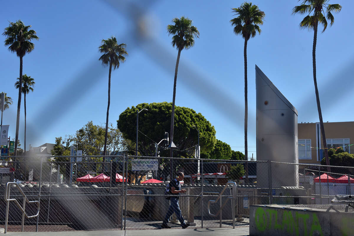 Un viajero sale de la estación BART de 24th Street, en medio de vallas improvisadas en el lado oeste de Mission Street, el martes 23 de agosto de 2022.