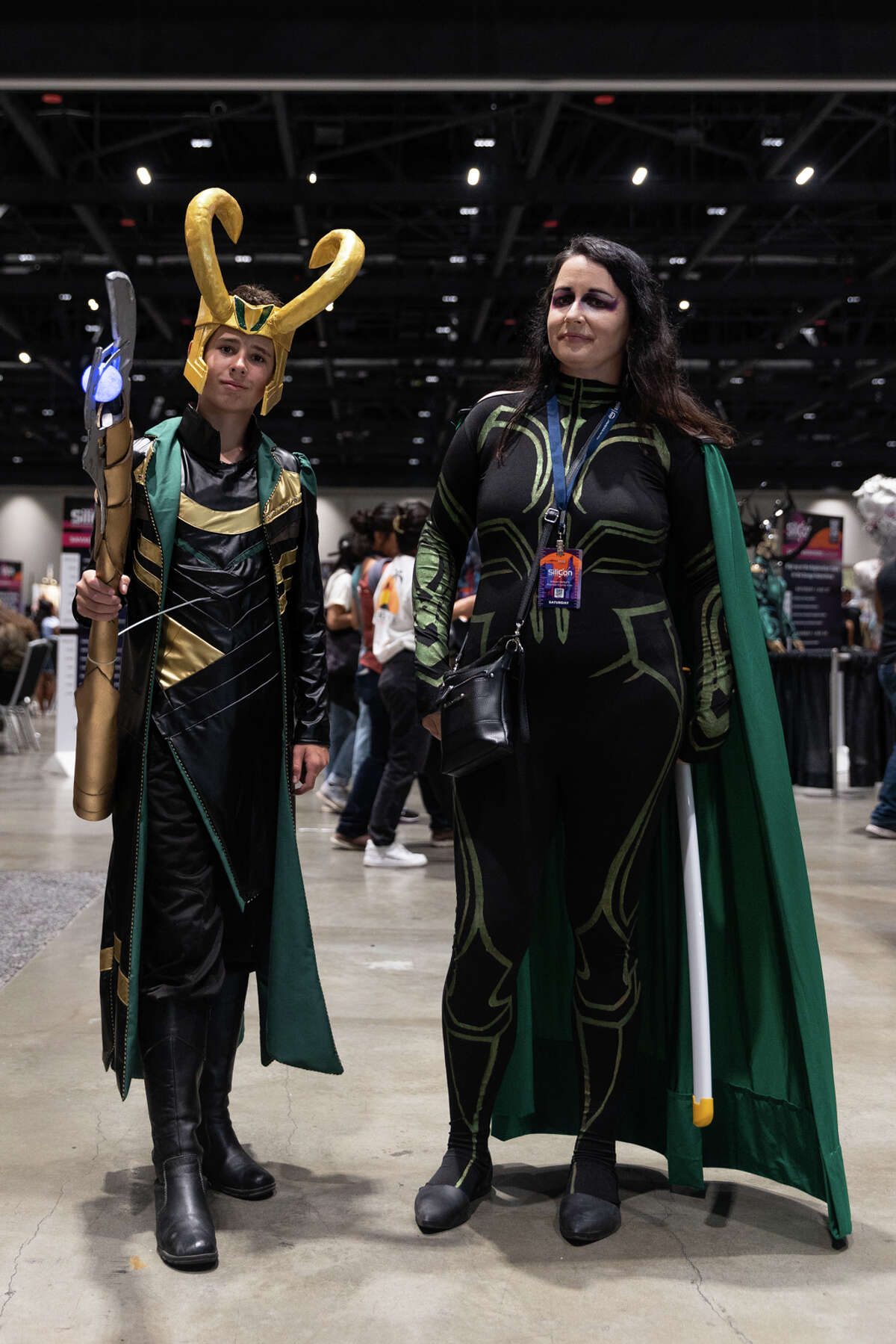 Simon Woodruff-McCarthy, a la izquierda, y su madre, Michelle Woodruff, a la derecha, vestidos como Loki y Hela del Universo Cinematográfico de Marvel en SiliCon con Adam Savage en el Centro de Convenciones McEnery de San José el 27 de agosto de 2022. 