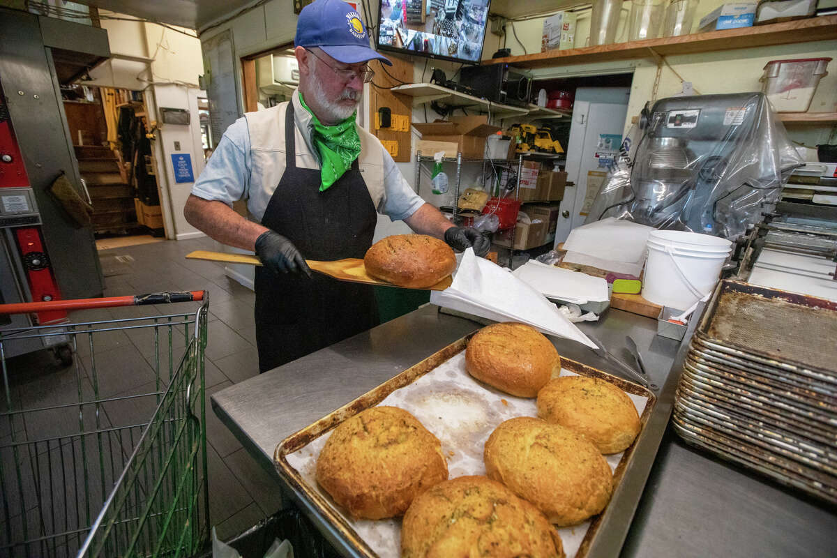 Baker Tom Shuman empaqueta algunos de los otros panes recién horneados en Arcangeli Grocery Co. en Pescadero, California, el 31 de agosto de 2022.
