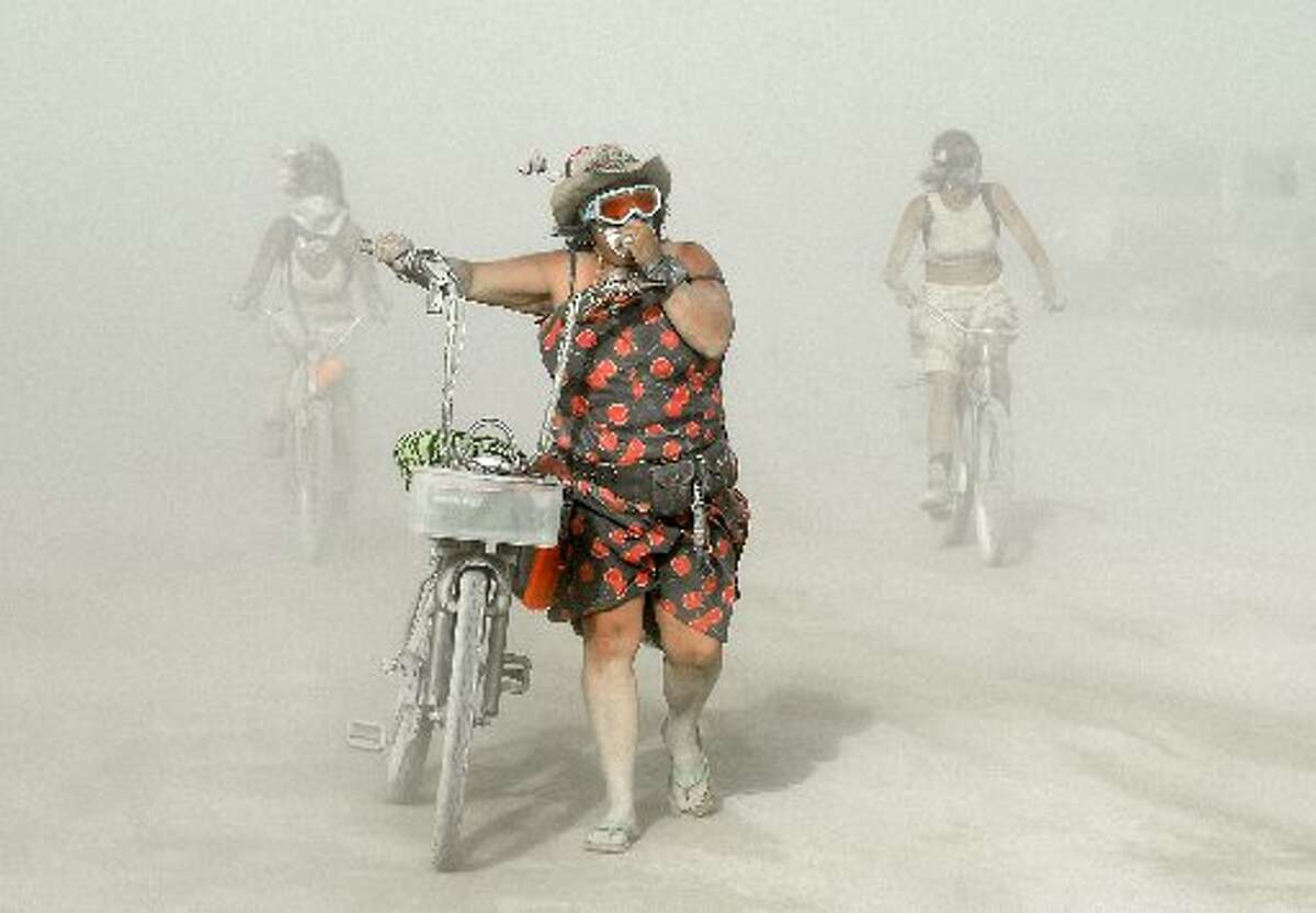 ARCHIVO - Los participantes se abren camino a través del polvo en Burning Man en el desierto Black Rock de Nevada el 2 de septiembre de 2015.
