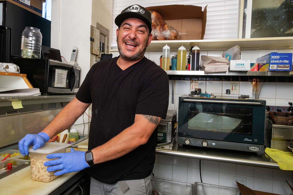 El propietario de McBaker Market & Deli, Joey Jada, se ríe mientras se prepara para el almuerzo a última hora de la mañana del viernes 12 de agosto de 2022.