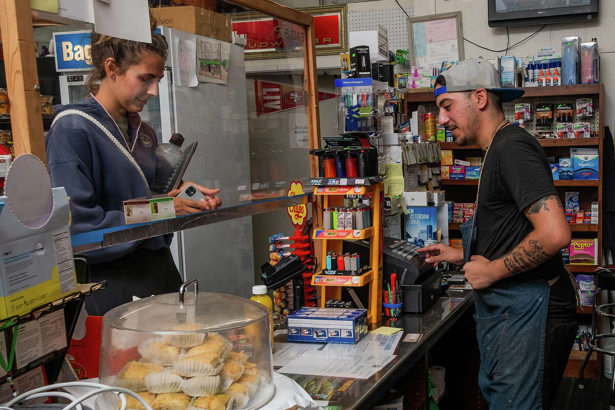 Louie Jada, a la izquierda, llama a la local del vecindario Sarah Dargen en McBaker Market & Deli en San Francisco el viernes por la tarde, 12 de agosto de 2022.