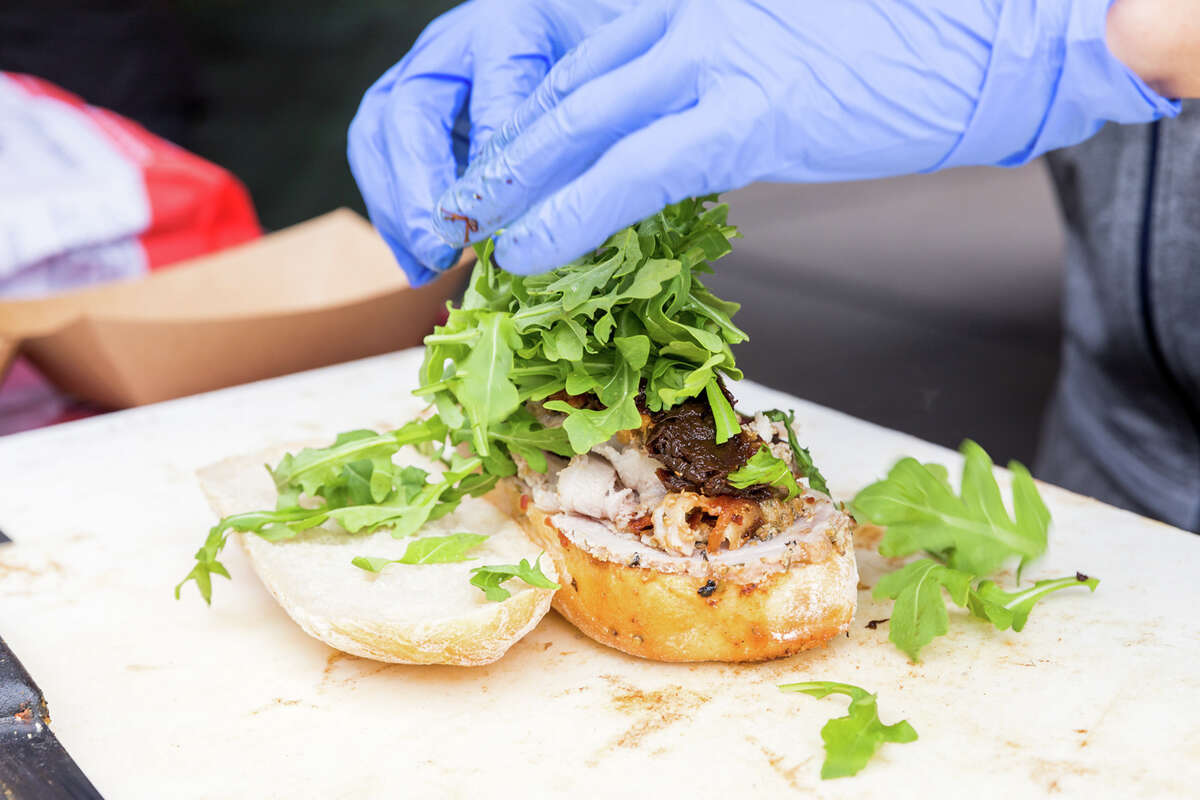 El personal prepara un sándwich de porchetta en el camión de comida Roli Roti en el Ferry Building en San Francisco, California, el 20 de septiembre de 2022.