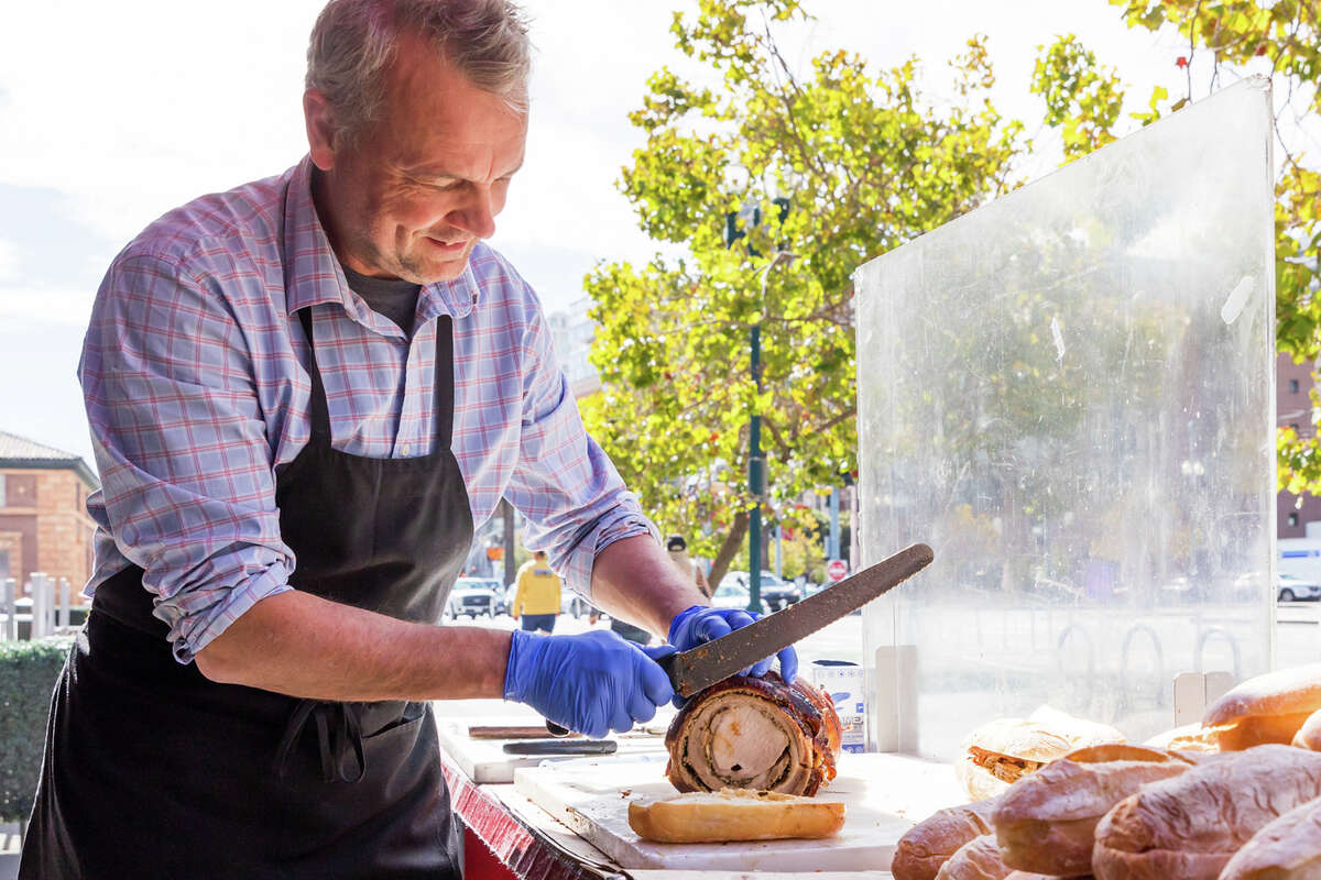 Thomas Odermatt cortando porchetta en el camión de comida Roli Roti en el Ferry Building en San Francisco el 20 de septiembre de 2022.