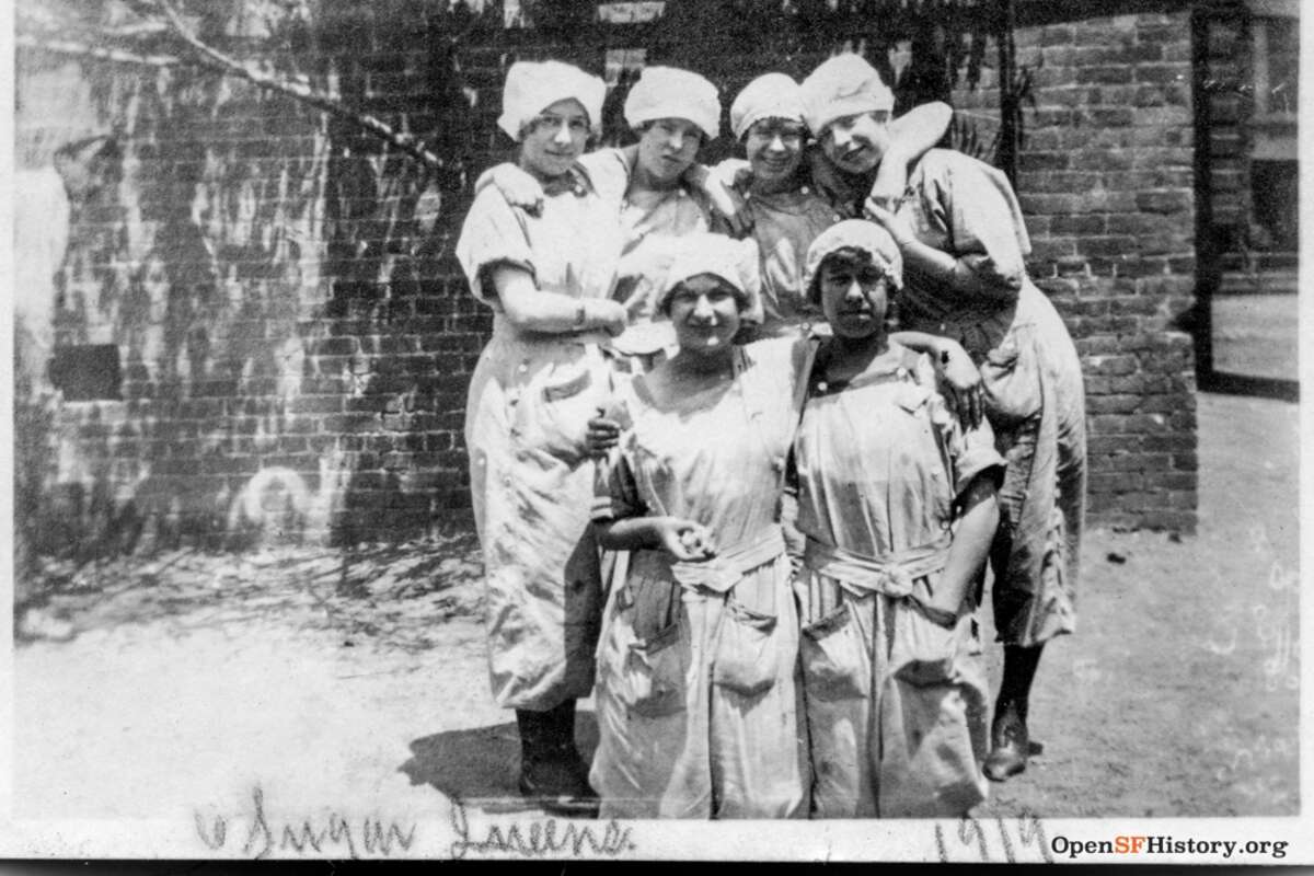 Seis trabajadoras azucareras posan detrás de Spreckels Sugar Factory. Una nota escrita a mano en la parte inferior de la fotografía dice: "6 Sugar Queens 1919".