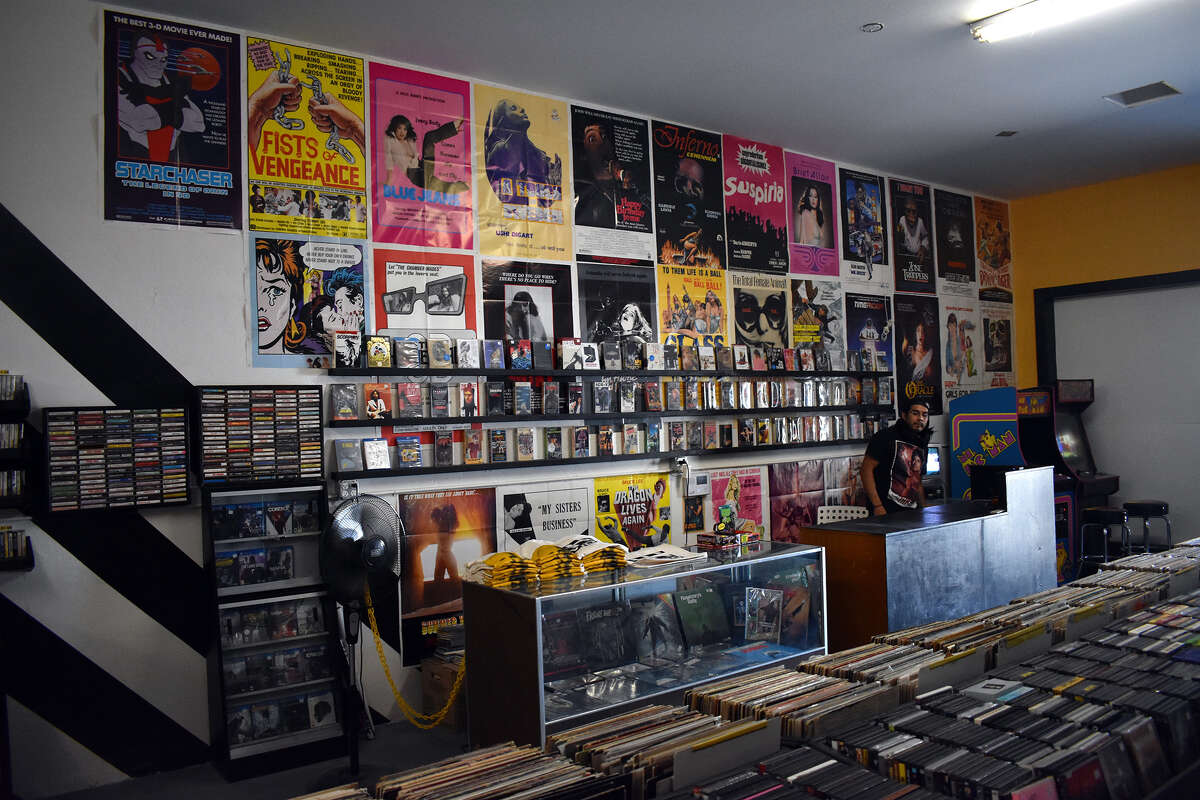 Miguel Hiracheta atiende el mostrador de Going Underground Video, una nueva tienda en Bakersfield dedicada a películas VHS clásicas descatalogadas y difíciles de encontrar, junto con música y videojuegos. 