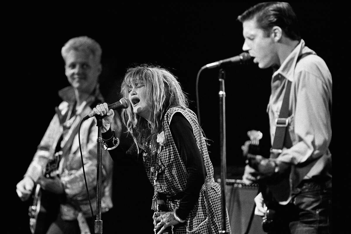La banda de punk rock de Los Ángeles X, de izquierda a derecha, Billy Zoom, Exene Cervenka y John Doe realizan un concierto de 1979 en Reseda, California. Aunque la banda nunca tuvo un éxito "Top 40", sí desarrolló un culto rabioso. influenciando a muchas otras bandas de la época. 