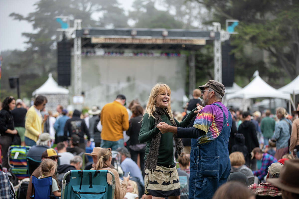 (De izquierda a derecha) Jane Glass y Joe Rafferty bailan con Sam Bush en el Banjo Stage en Hardly Strictly Bluegrass en el Golden Gate Park en San Francisco el 30 de septiembre de 2022.