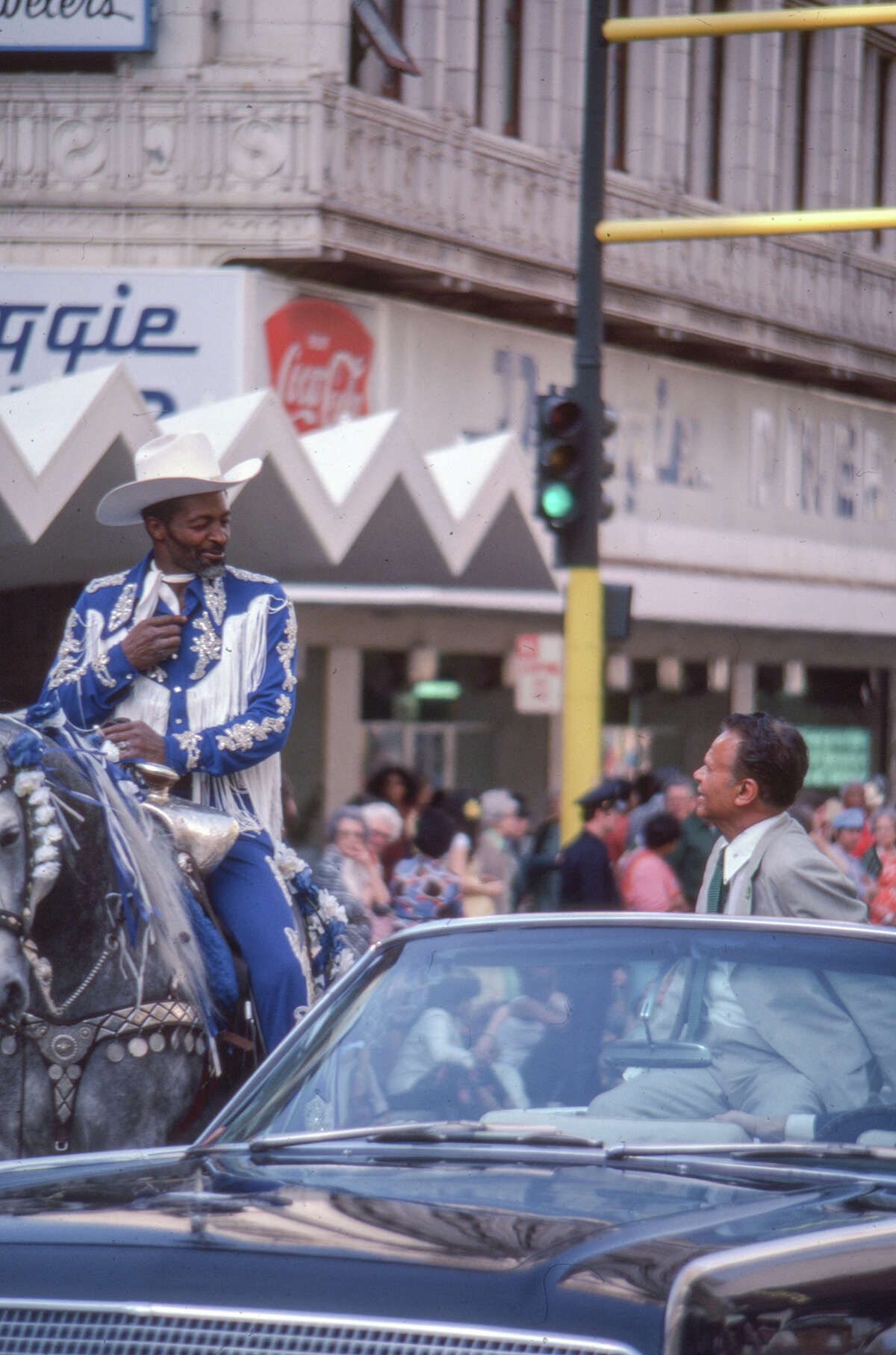 El exalcalde de Oakland, Lionel Wilson, conversa con un vaquero negro a caballo frente a Doggie Diner, anteriormente en Broadway en Oakland. Fecha desconocida. 