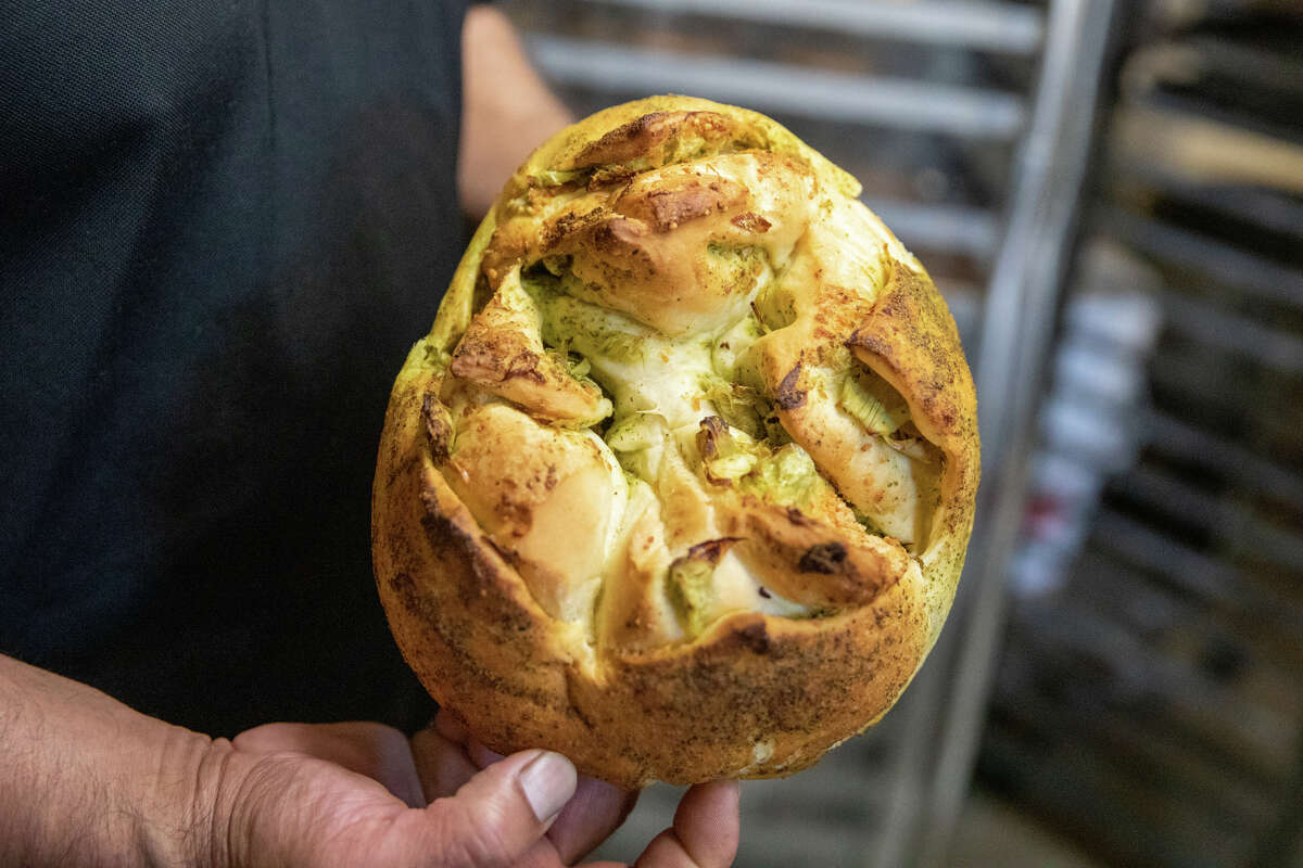 La propietaria Desi Sanchez sostiene uno de los panes de pesto de alcachofas en Half Moon Bay Bakery en Half Moon Bay, California, el 19 de octubre de 2022.