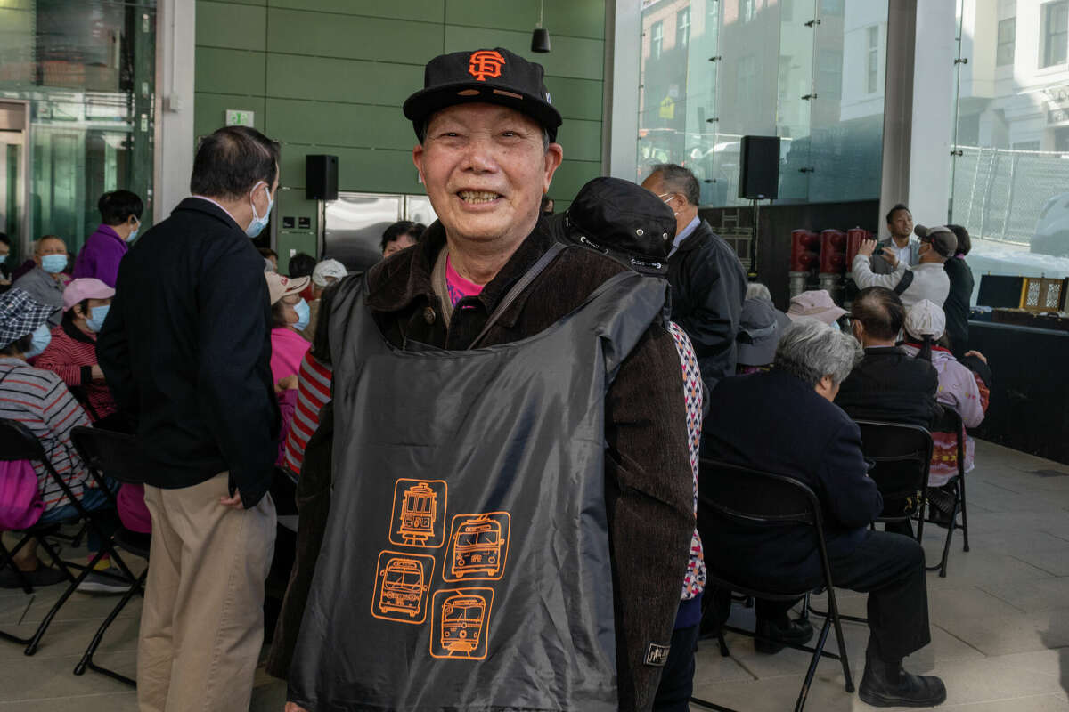 Un invitado de la comunidad local muestra su nueva bolsa de regalo Muni durante una vista previa especial de la nueva estación Rose Pak de Chinatown del vecindario el jueves 20 de octubre de 2022.