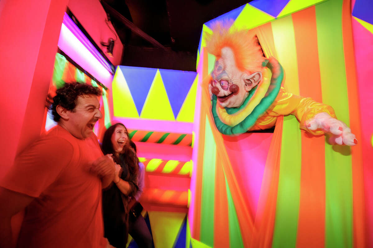 Los asistentes caminan por la casa "Killer Klowns From Outer Space" durante Halloween Horror Nights en Universal Studios Hollywood. 