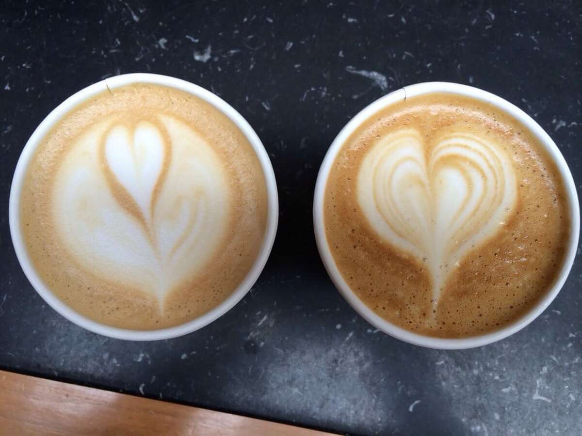 Dos cafés con leche con corazones en forma de espuma se sientan en el mostrador de Blue Bottle Coffee en el vecindario de Hayes Valley en San Francisco. 
