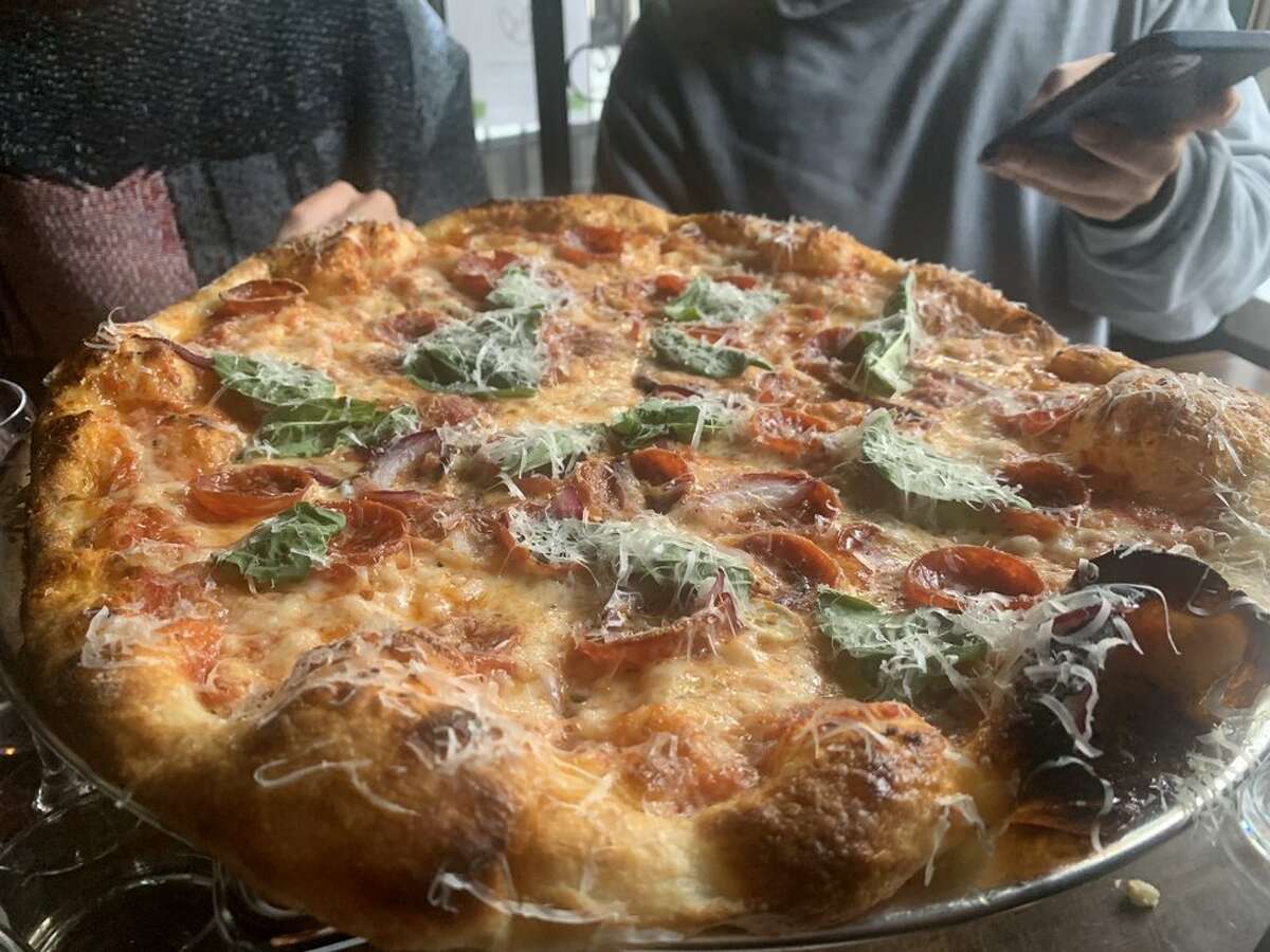 Una persona toma una foto de una pizza de Fig & Thistle en el vecindario Hayes Valley de San Francisco.