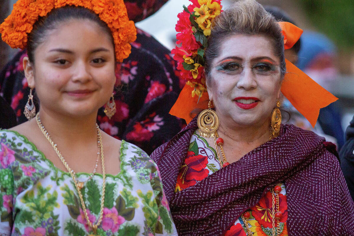 Lydia Candila, a la derecha, y su hija Lucía Gómez, del Distrito de la Misión, esperan el inicio de la 41.ª procesión anual del Día de los Muertos en Bryant Street el miércoles.