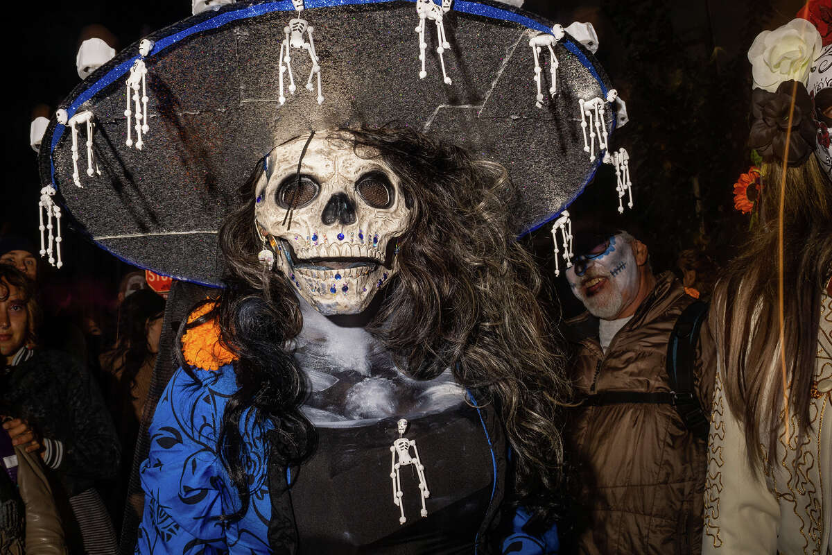 Los asistentes usan ropa adornada en la procesión del Día de los Muertos y la celebración general a lo largo de la calle 24 en el Distrito de la Misión de San Francisco el miércoles.