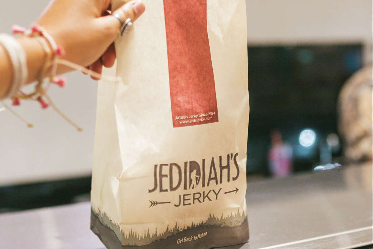 Una persona que sostiene una bolsa de Jedidiah's Jerky ubicada dentro de EddieWorld en Yermo, CA.