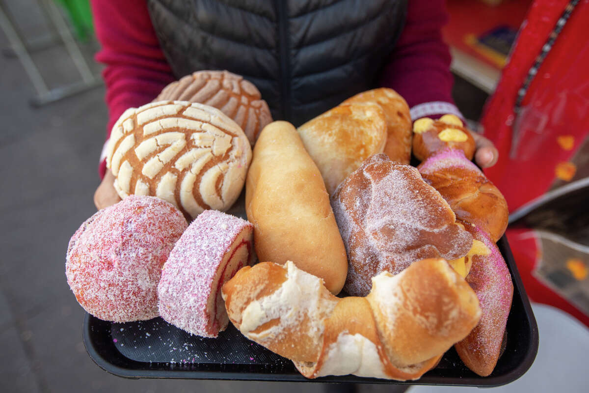 La propietaria Carmen Elias sostiene una bandeja de la variedad de pan dulces disponibles en La Mejor Bakery en el Distrito de la Misión de San Francisco, California, el 27 de octubre de 2022.