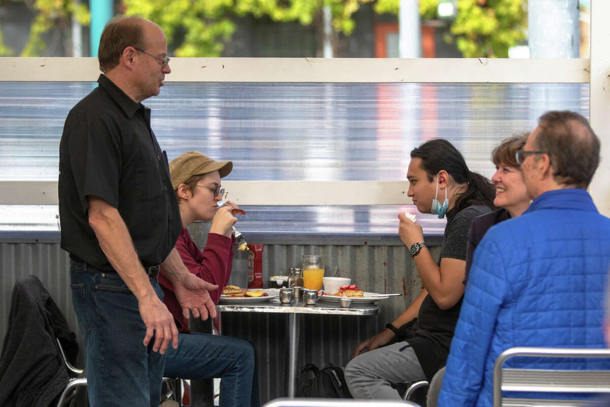Douglas Smith, a la izquierda, habla con clientes en Rudy's Can't Fail Cafe en Emeryville, California, el 4 de noviembre de 2022.
