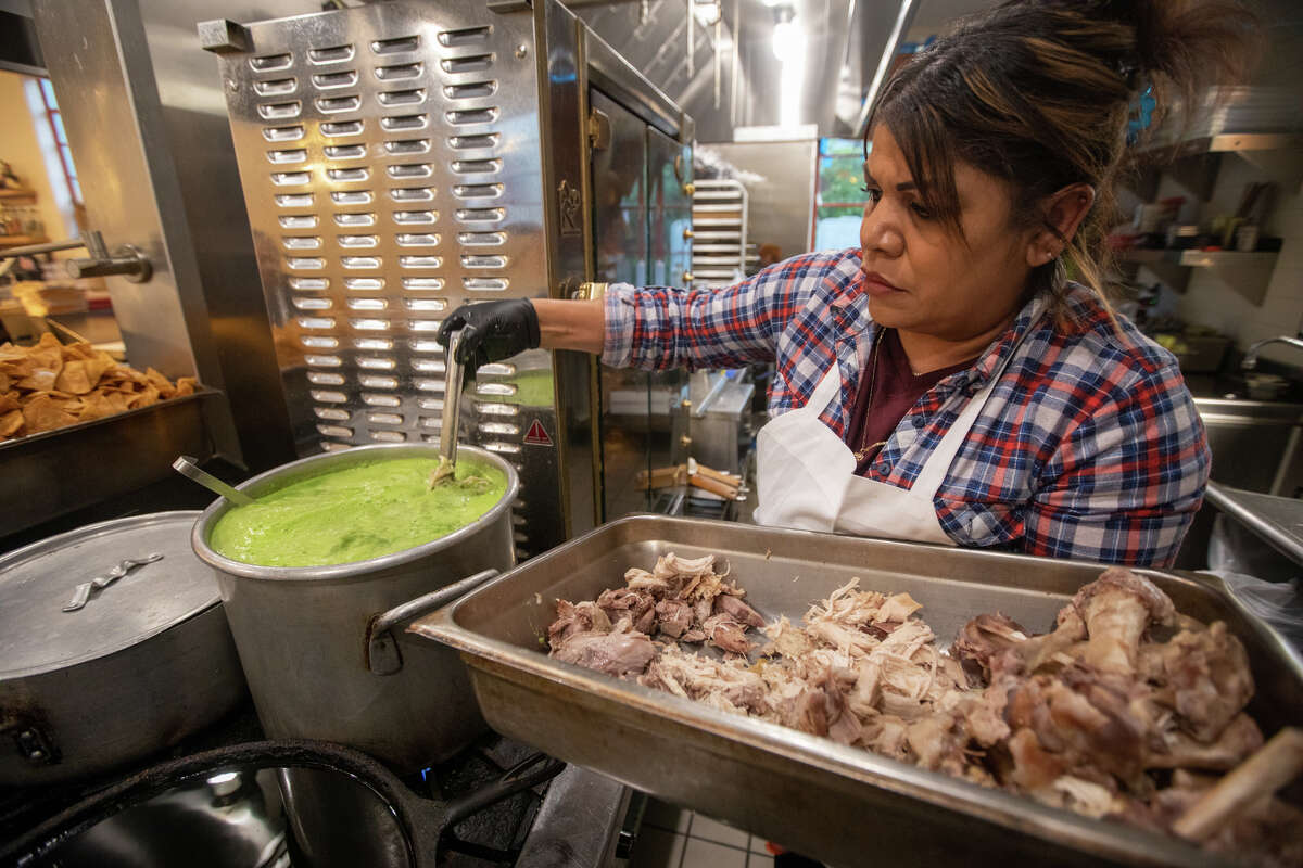 Mélida Rodríguez, miembro del personal de cocina, agrega pollo desmenuzado al pozole verde que se sirve en Bombera en Oakland. 