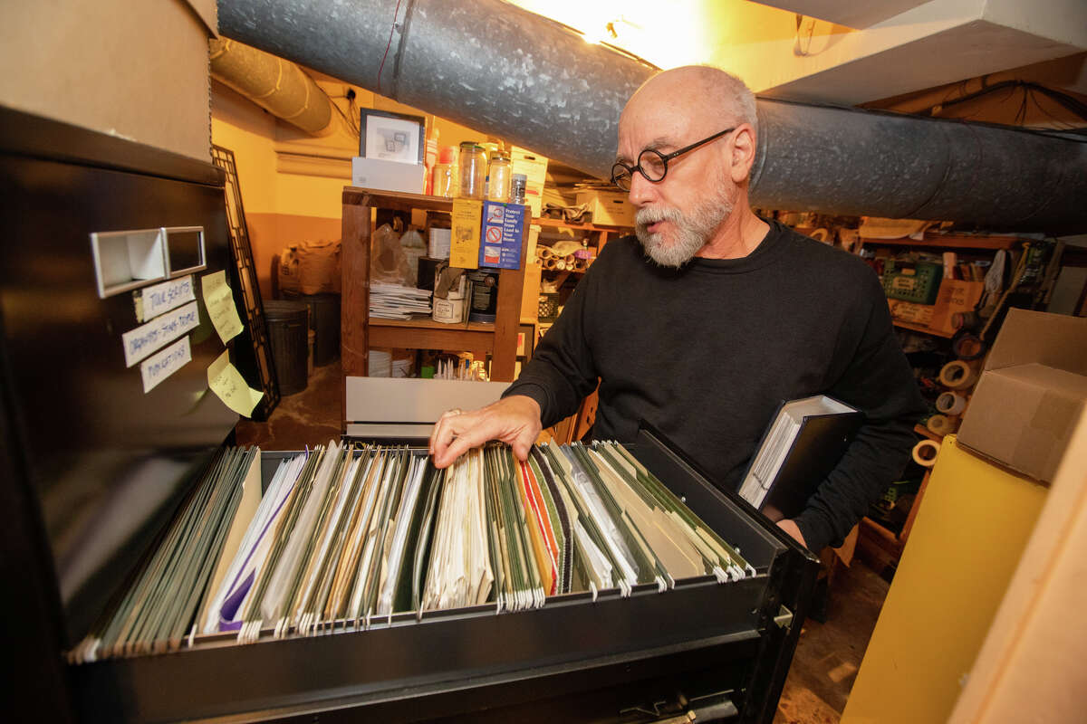 El curador y restaurador David Boysel revisa su archivador de las renovaciones que supervisó en el Teatro Paramount en Oakland el 14 de noviembre.