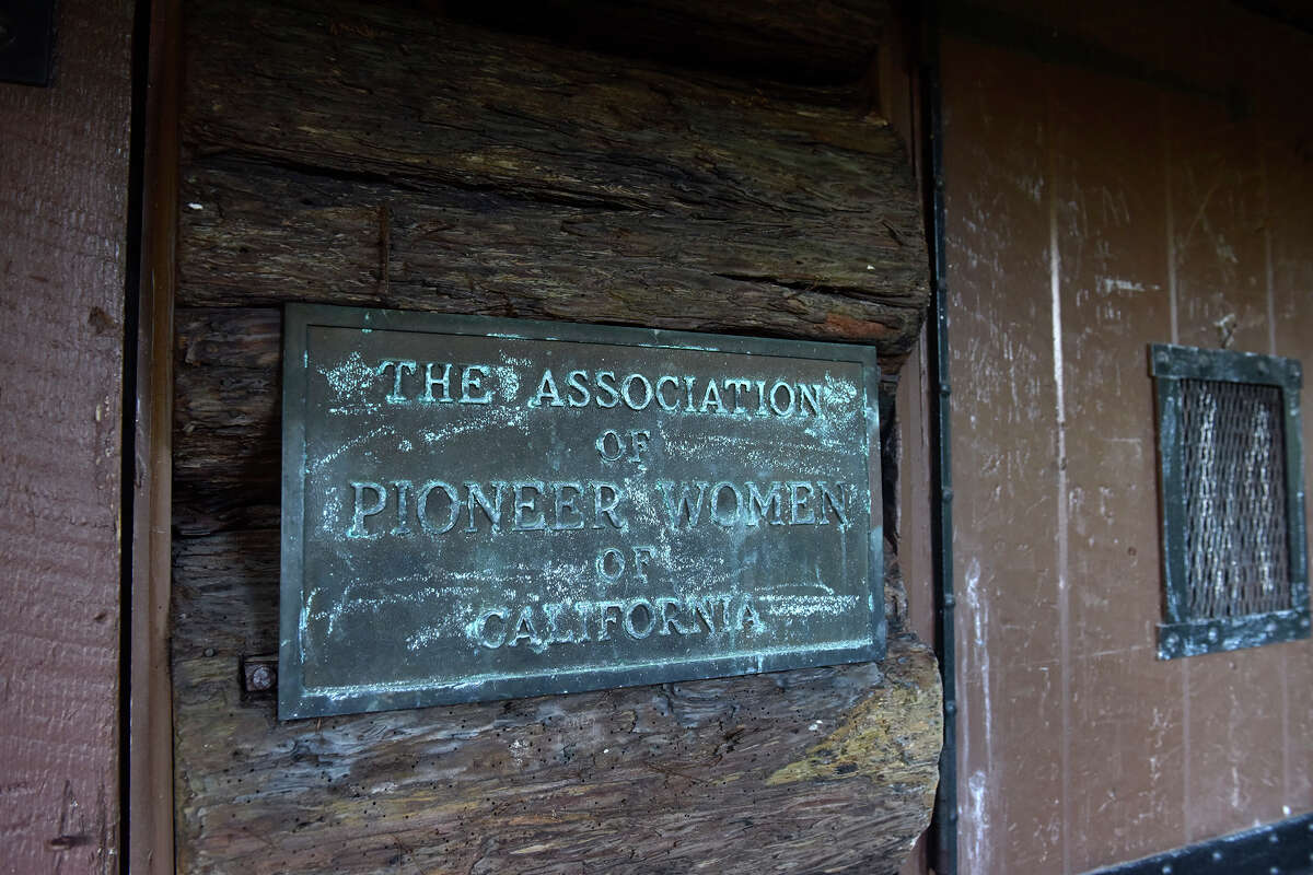 Una placa junto a la puerta principal de Pioneer Log Cabin en Golden Gate Park conmemora sus orígenes como lugar de reunión de la Asociación de Mujeres Pioneras de California.