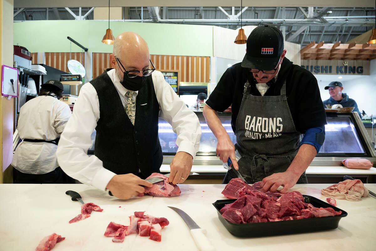 David Samiljan y Alex Olson preparan carne en Baron's Quality Meats & Seafood dentro de Alameda Marketplace en Alameda, California, el 29 de noviembre de 2022.