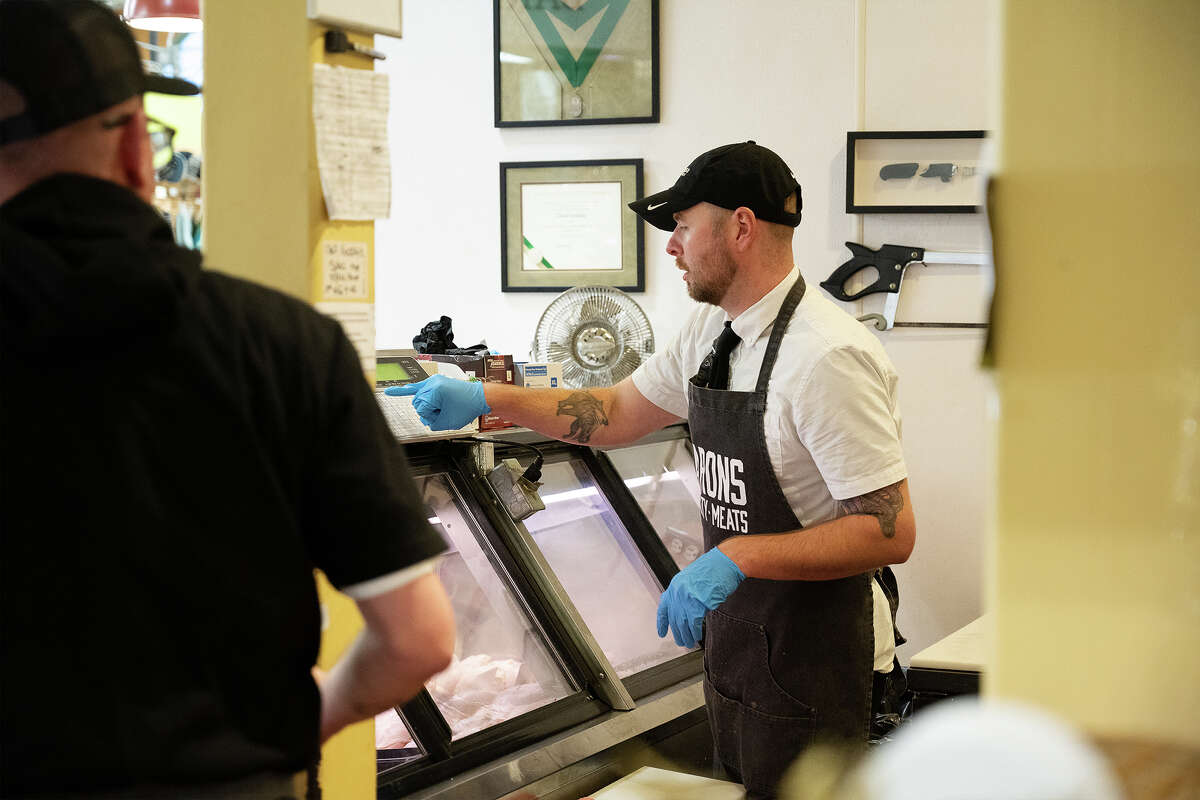 Lucas Jackson ayudando a un cliente en Barons Quality Meats and Seafood dentro de Alameda Marketplace en Alameda CA, 29 de noviembre de 2022