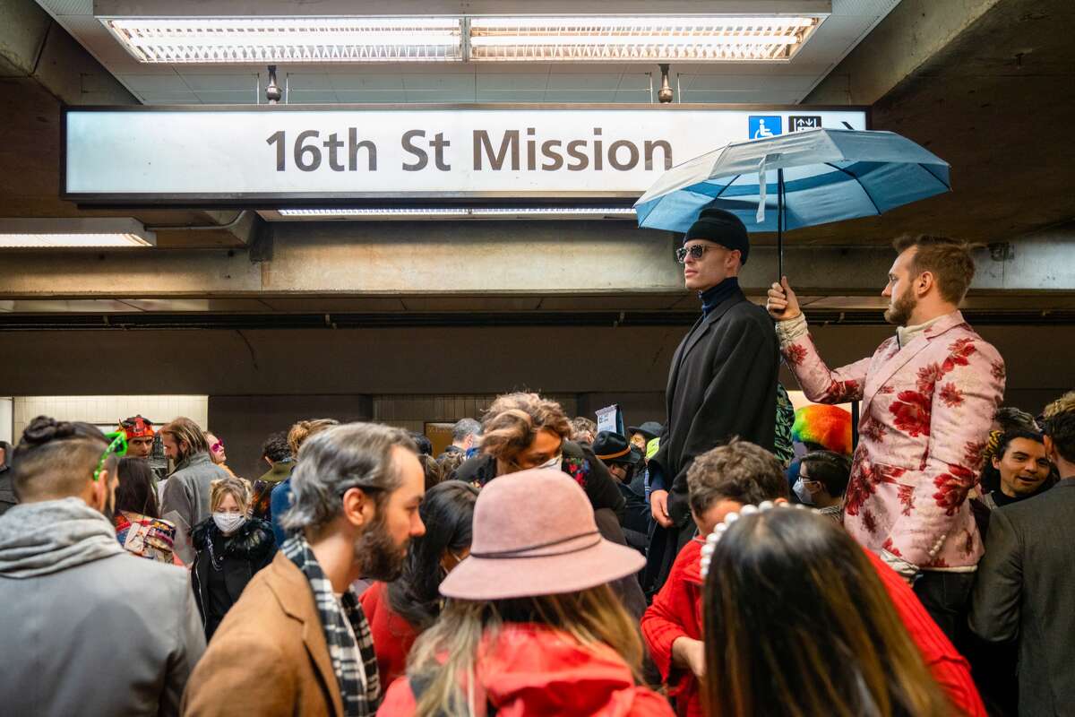 Los asistentes a la exhibición de arte BART Basel 2022 se dirigen hacia los vagones de BART en la estación 16th St. Mission mientras se dirigen a la siguiente parada de la exhibición de arte en el centro de San Francisco, California, el sábado 3 de diciembre de 2022.