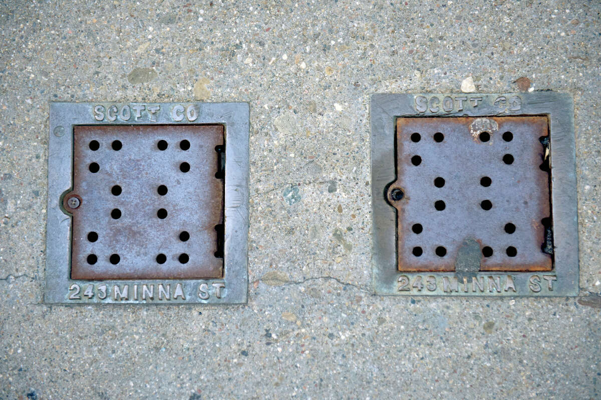 Un par de tapas de rejillas de alcantarillado en Bush Street (no Minna) en el centro de San Francisco. 