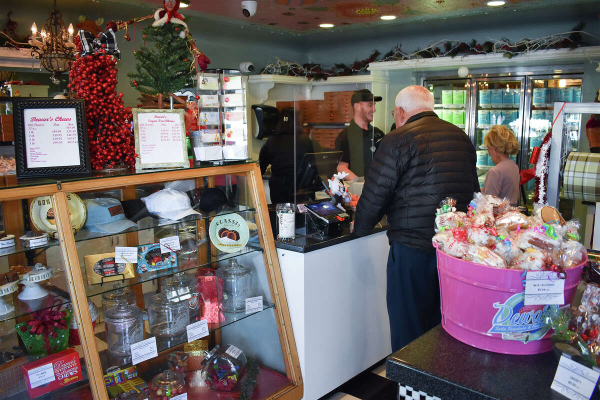 Un cliente paga sus regalos navideños de Dewar's masticables y chocolates caseros en el centro de Bakersfield, el 8 de diciembre de 2022. 