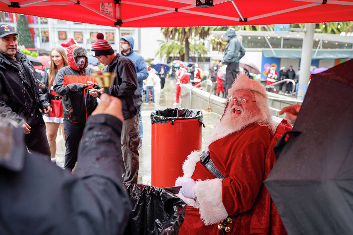 Papá Noel permanece alegre bajo la lluvia torrencial durante la SantaCon 2022 en Union Square en San Francisco, el sábado 10 de diciembre de 2022. 