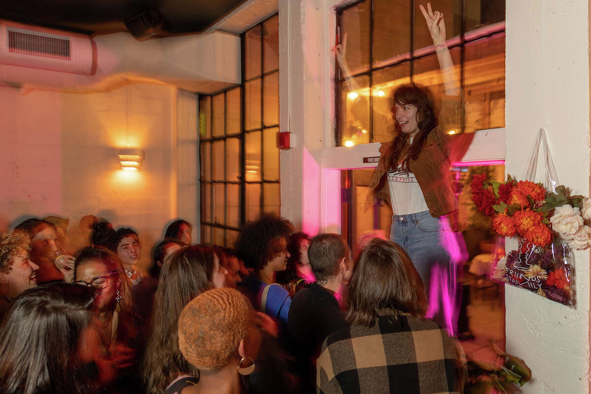 Elizabeth Audra, presentadora invitada y maestra de ceremonias de Queer Speed ​​Dating, se dirige a la multitud durante el evento especial en Friends and Family, un bar en Uptown Oakland, el domingo 20 de noviembre de 2022 por la noche.