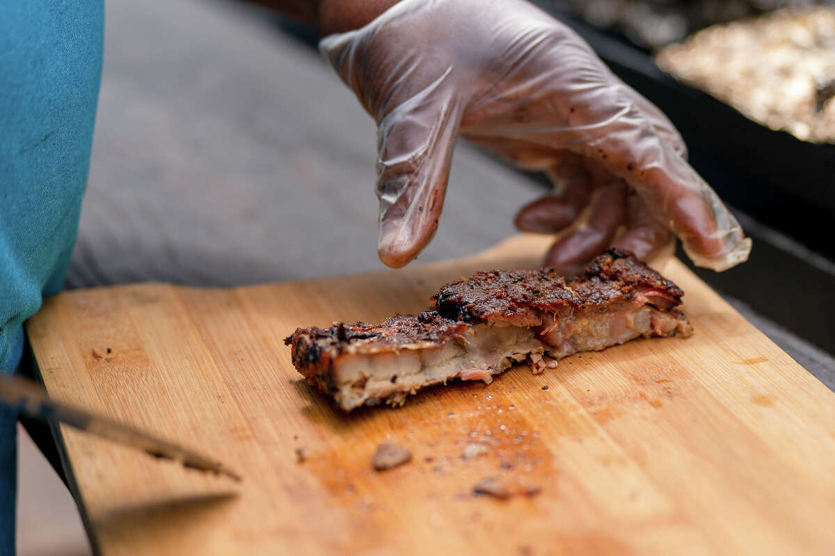 Corte una costilla BBQ para un cliente en Adams BBQ en North Beach de San Francisco, California, el viernes 29 de julio de 2022.