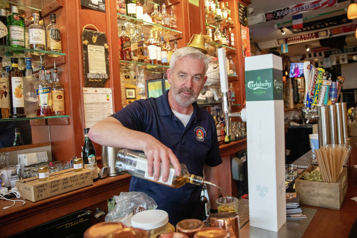 Brian Coyle, propietario de Danny Coyles, toma un pedido detrás de la barra de su bar en Haight Street en San Francisco, California, el 13 de enero de 2023.
